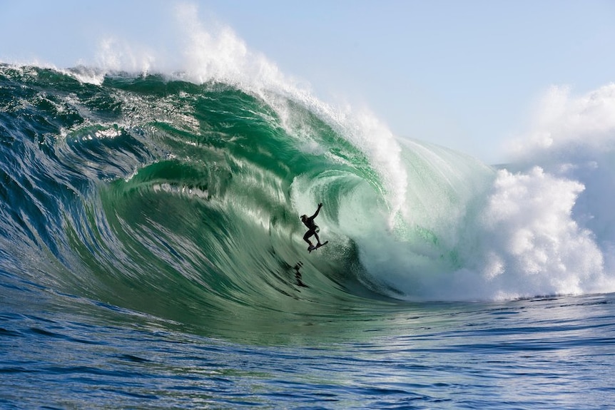 Ryan Hipwood surfing large wave at Shipstern Bluff in Tasmania.