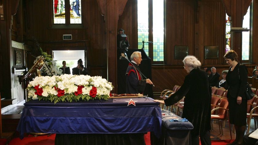 Lady Hillary touches the casket of her husband