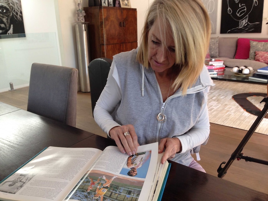 Jane Flemming looking at a book about Australian Olympians