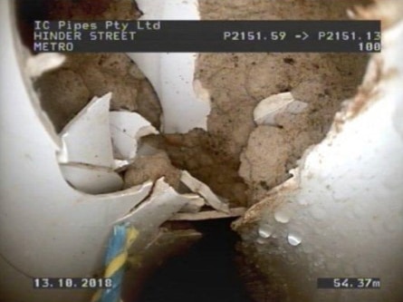 Inside a broken pipe with damaged electrical conduits.