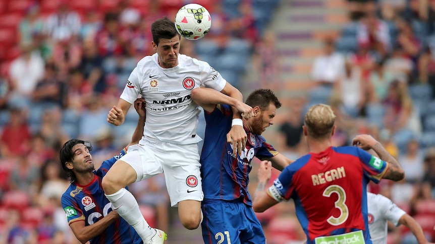 Aerial challenge ... Tomi Juric heads the ball over Daniel Mullen