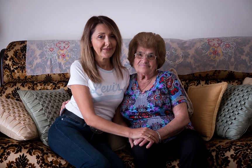 Two women sit on a couch.