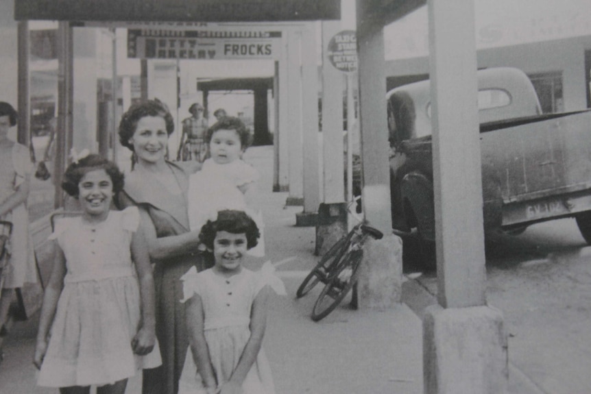 A lady stands with her three children outside a shop in Macksville.