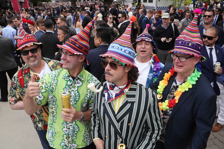 Racegoers in colourful outfits during the Melbourne Cup Day at Flemington racecourse.