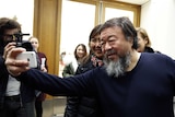 Chinese artist Ai Weiwei takes a selfie with a woman.