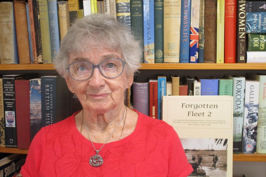 Dr Ruth Lunney looks directly at the camera in front of a book shelf. Her book is turned out so you can read the title: Forgotte