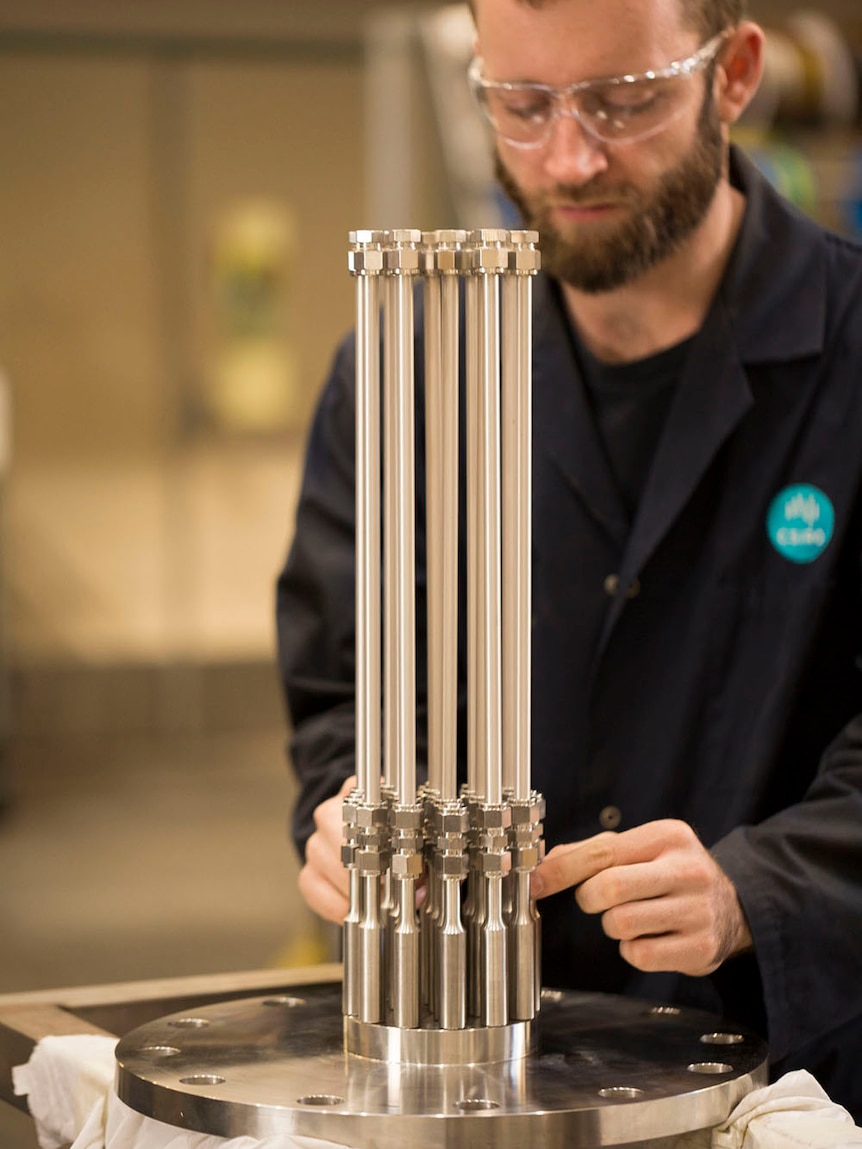 A researcher stands with H membrane technology device.