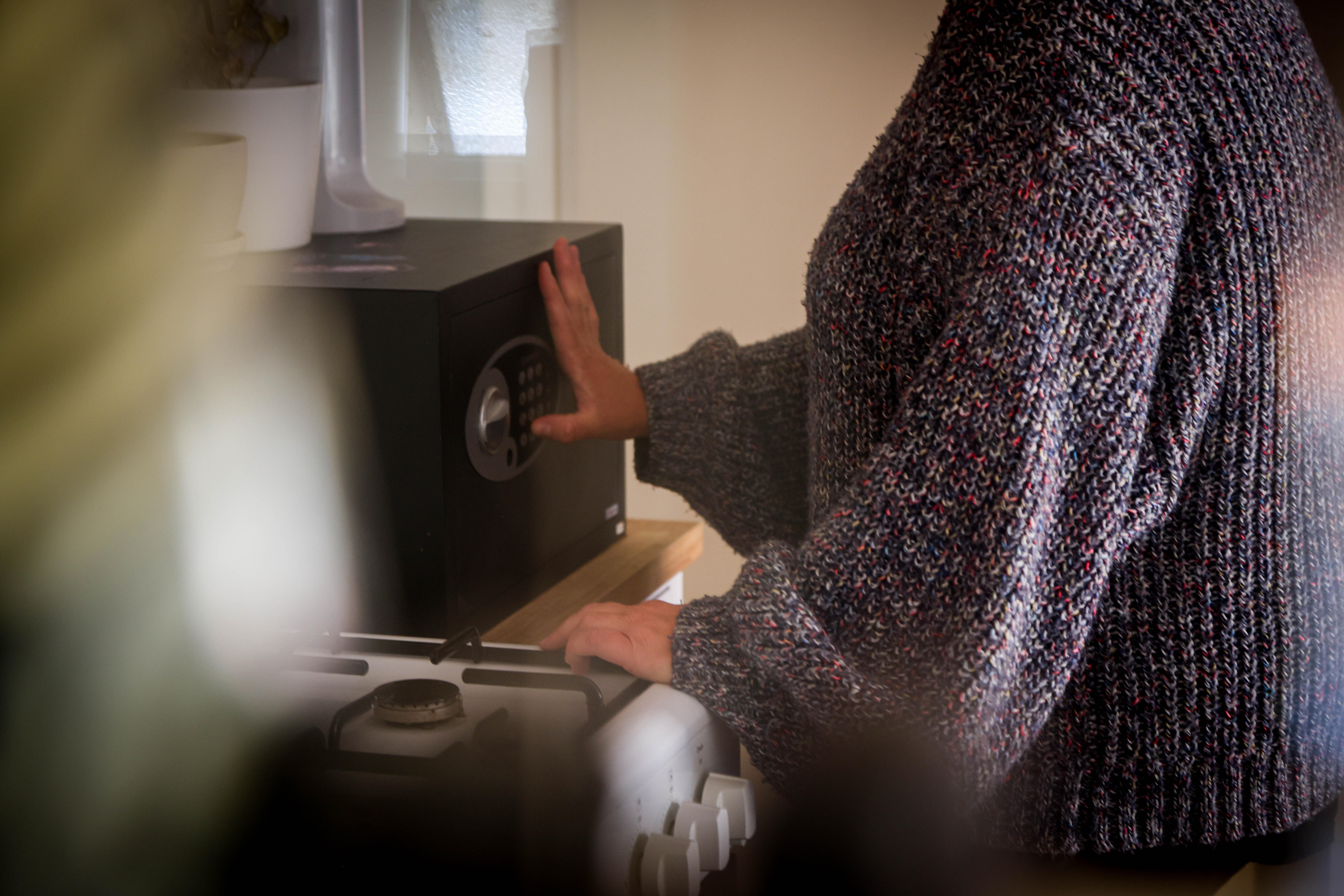 Ella opening the safe in her kitchen.