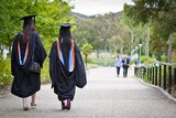 Two women wearing University graduation gowns and mortar boards.