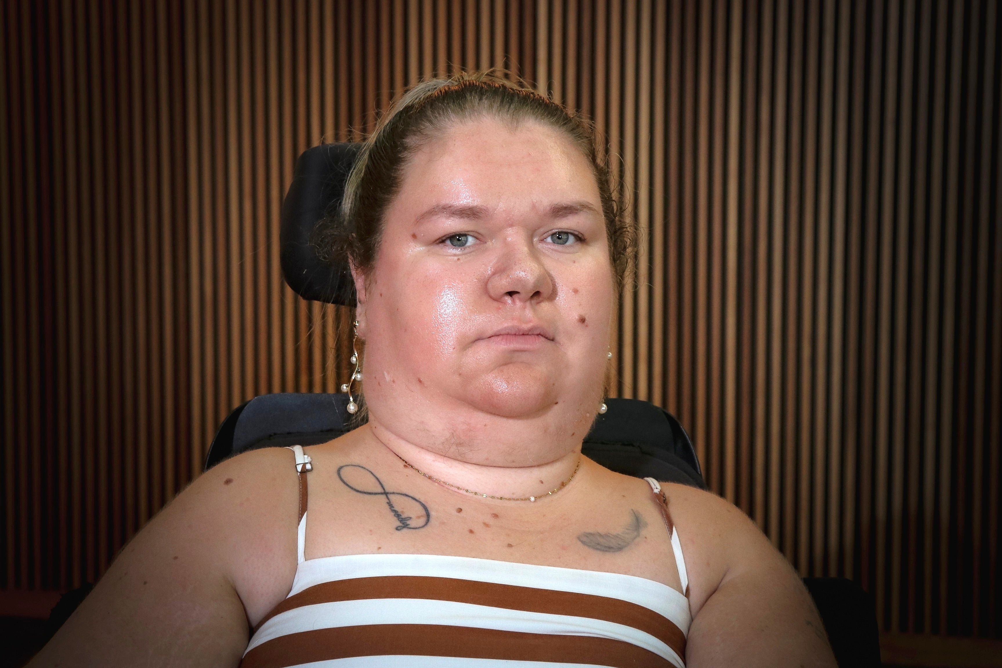 A woman in a wheelchair with her hair tied up