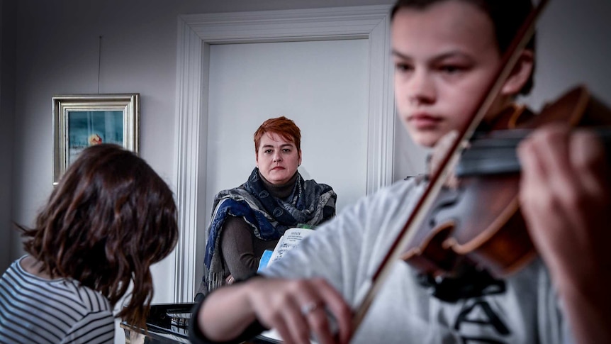 Lisa Polsek (centre) and her daughters (Left) Ellen Polsek 16yrs and Alexandra Polsek 13yrs are seen at home playing music.