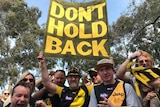 Richmond fans hold a sign saying 'don't hold back' ahead of the team's preliminary final against GWS.