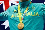 Cropped image of Kyle Chalmers standing on the Olympic podium with a gold medal.