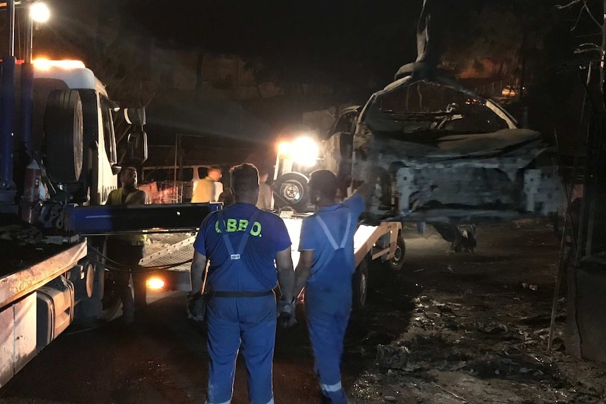 Crews attend to burned cars in Mati, Greece