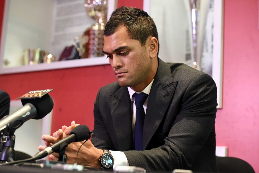 Karmichael Hunt looks at hands with serious expression during press