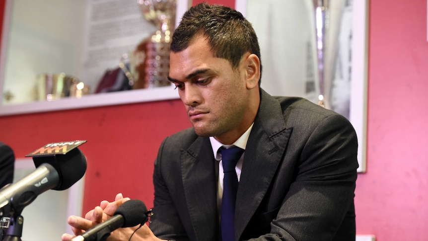 Karmichael Hunt looks at hands with serious expression during press