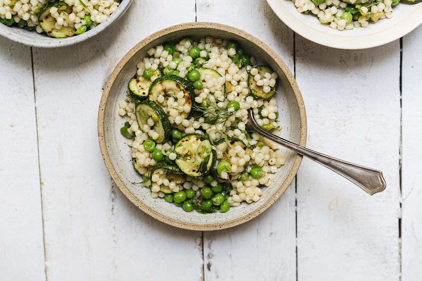 Zucchini, peas, pearl coucous salad in a bowl