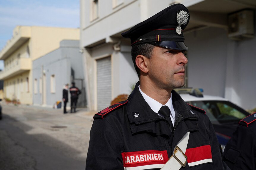 A policeman stands in a Sicilian street