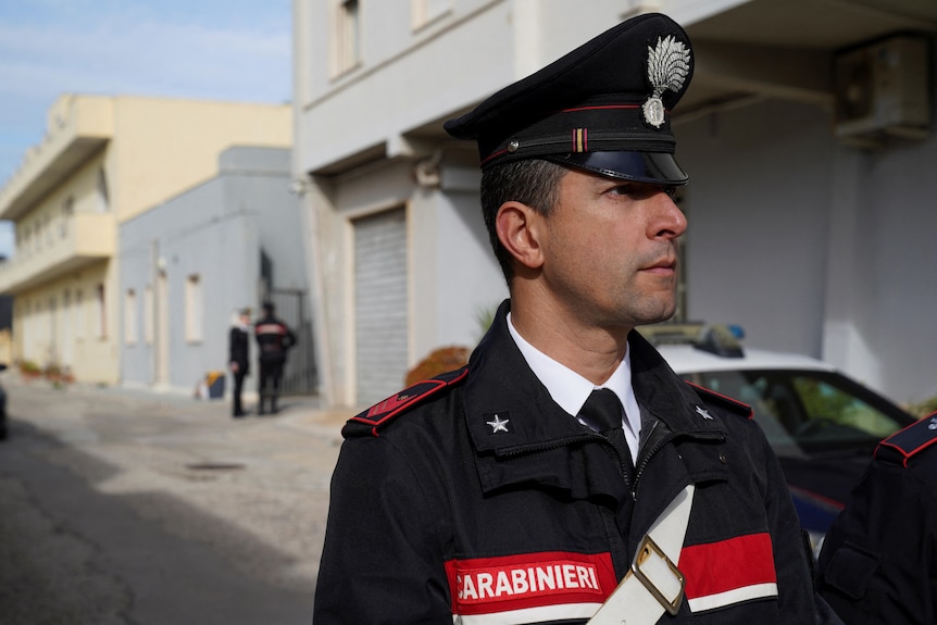 A policeman stands in a Sicilian street