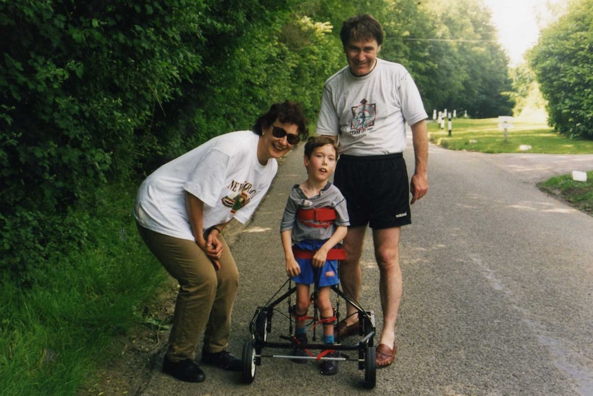 Shane O'Reilly takes his first steps with aid of a Hart walker, watched over by parents Sue and David in 1997.