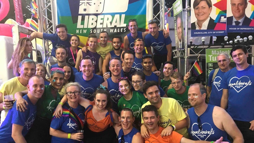 A large group in front of a Liberal Party Mardi Gras float.