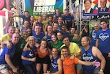 A large group in front of a Liberal Party Mardi Gras float.
