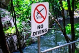 sign above a rocky creek.