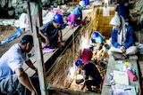 Workers excavating at a cave entrance