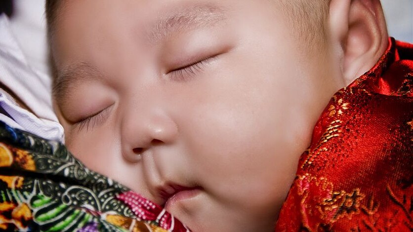 A sleeping baby wearing red.