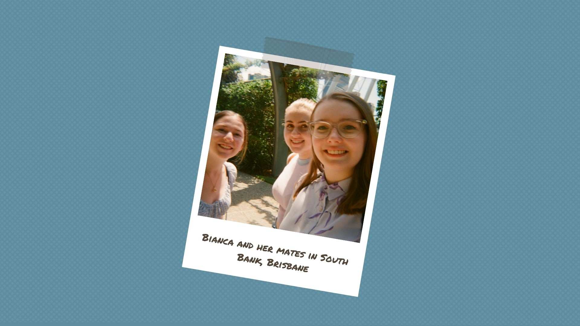 A young woman with glasses stands under an archway with two friends