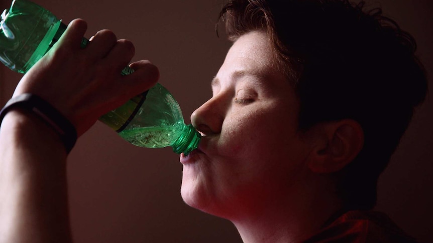 Young man with soft drink bottle