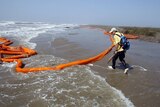 Twisted oil booms wash ashore