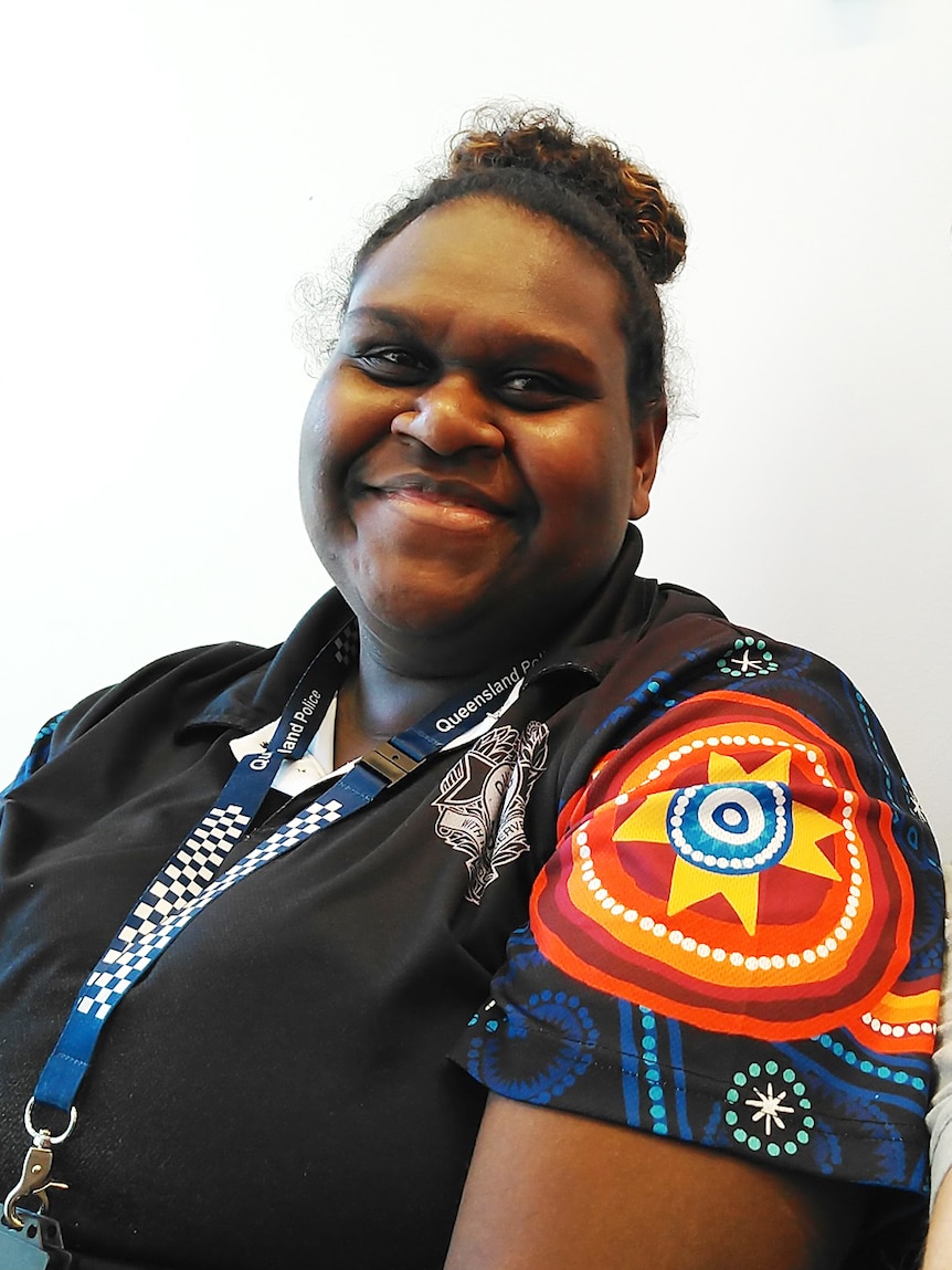 Indigenous woman Naz Wapau smiles, while dressed in uniform as assistant recruitment officer with the Queensland Police Service.