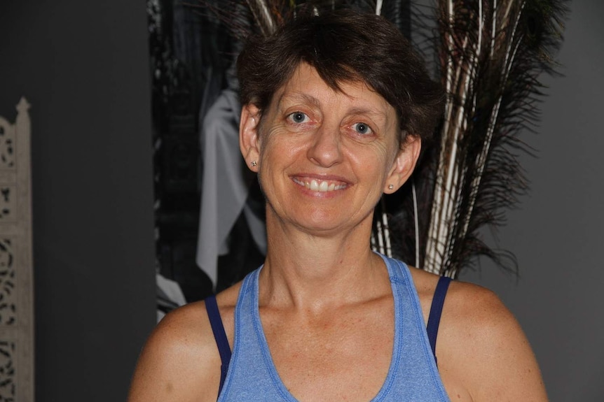 A head and shoulders image of yoga instructor Tracey Bienek smiling at the camera, wearing gym gear.