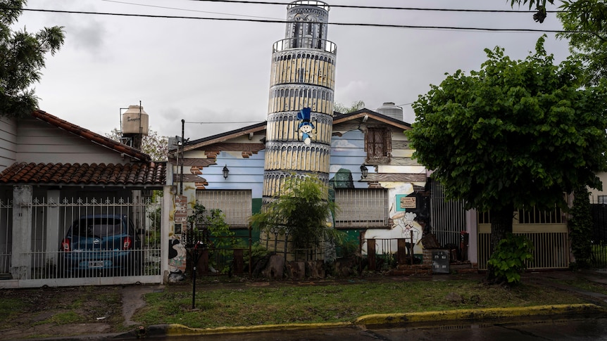 A replica of the leaning tower of Pisa in the front garden of a house. 