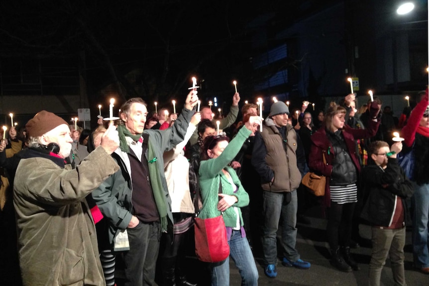 A crowd of people holding up candles in St Kilda one year on from the death Tracey Connelly.