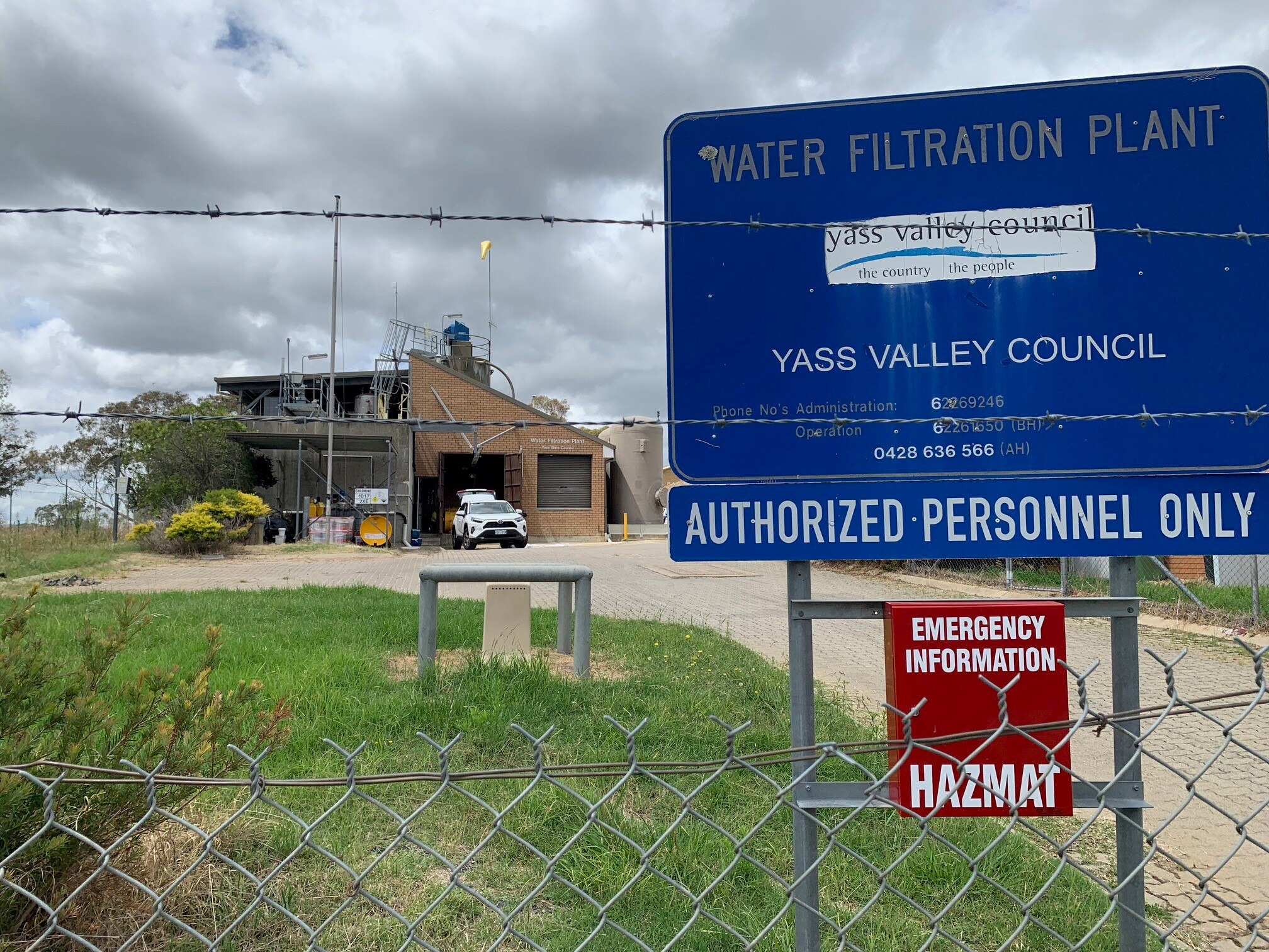 A wire fence with a plant in a background, and a sign which says Water Filtration Plant