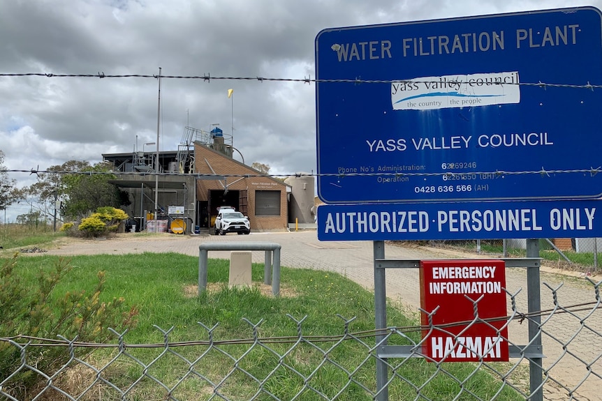 A wire fence with a plant in a background, and a sign which says Water Filtration Plant