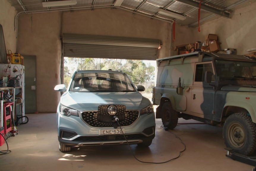 Un vehículo eléctrico azul cargando en un garaje.