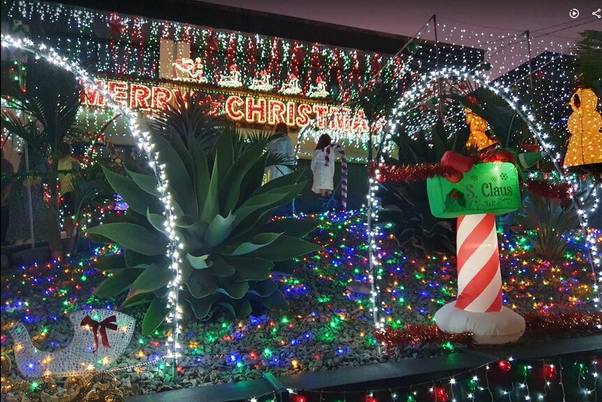 A front yard of a house decorated with excessive christmas lights.