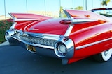 The back end of a red shiny classic car