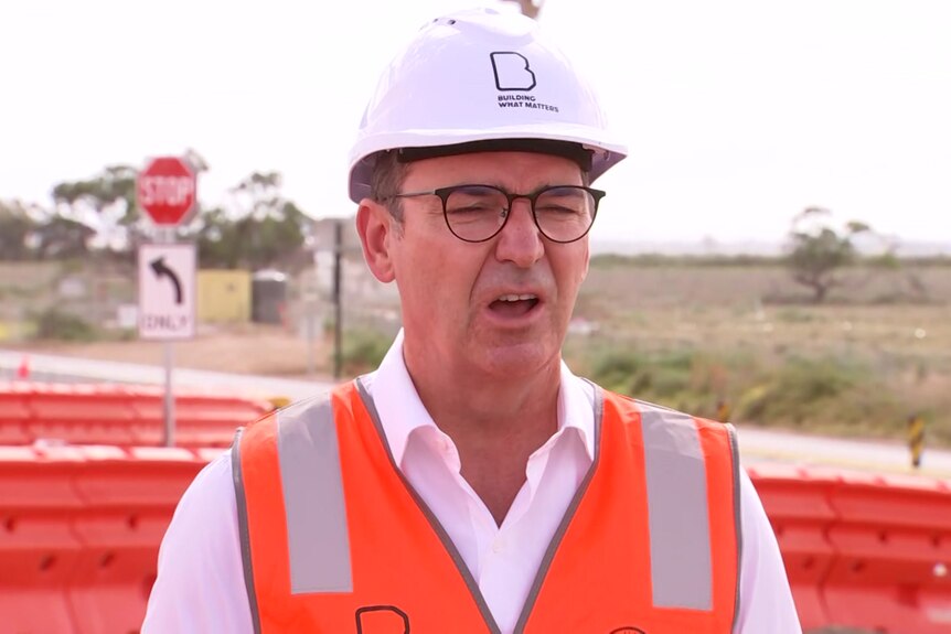 A man wearing a hard hat and an orange vest