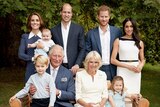 Prince Charles sits on a garden bench with grandson George on his knee, surrounded by his wife, sons and their families, smiling