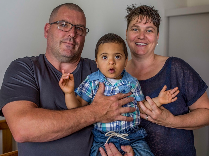 Peter and Emma hold their newly-adopted son, Daniel* who has Down syndrome.