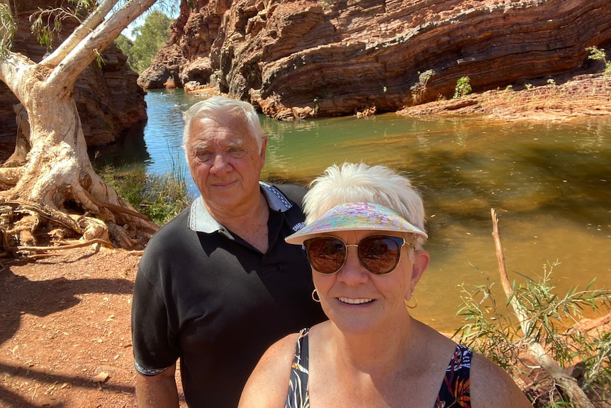 An older couple at a desert rock pool.