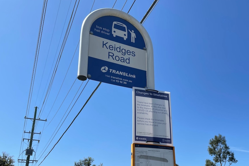 A sign at a bus stop warns commuters that services from the route have been impacted due to ongoing bus driver shortages.