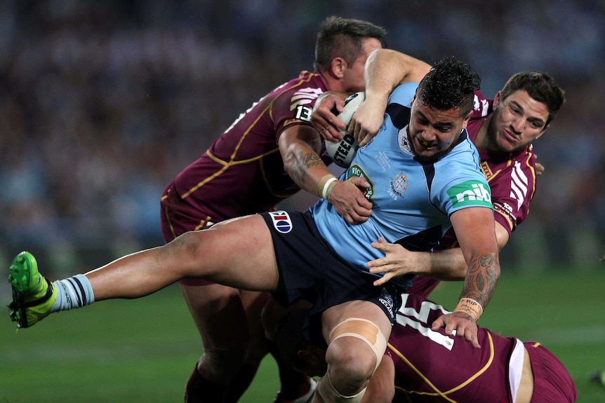 Maroons players tackle NSW's Andrew Fifita