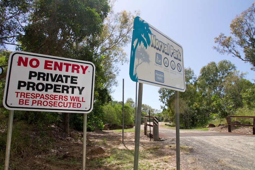 Two signs are placed next to each at the entry of a campground