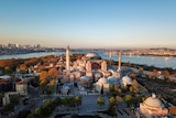 An aerial view of the Hagia Sophia with the sea and city of Istanbul in the background.