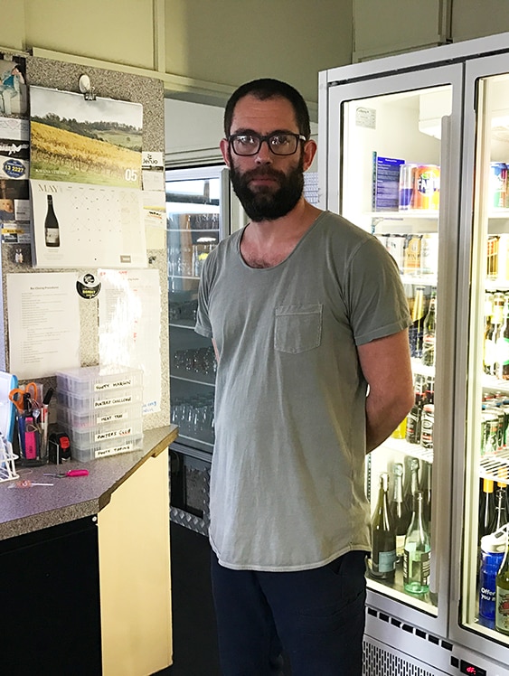 Bearded man in bar area of hotel.